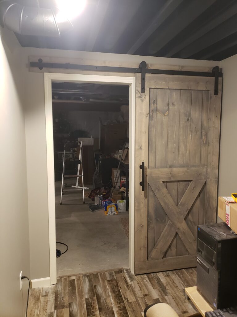 Sliding barn door hardware added, header board installed, and door hung