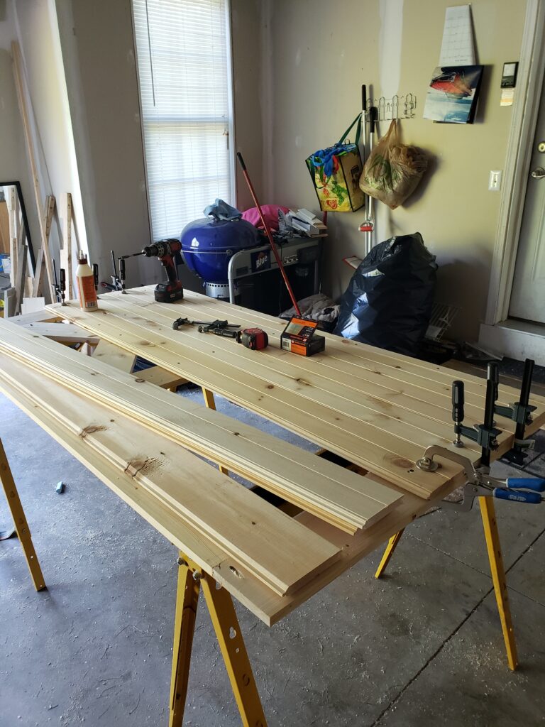 Clamping together tongue and groove board for sliding barn door assembly